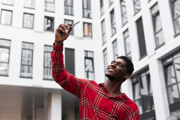 Young adult in red shirt taking a self photo