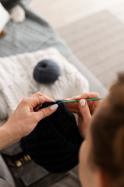 Free photo young adult relaxing while knitting