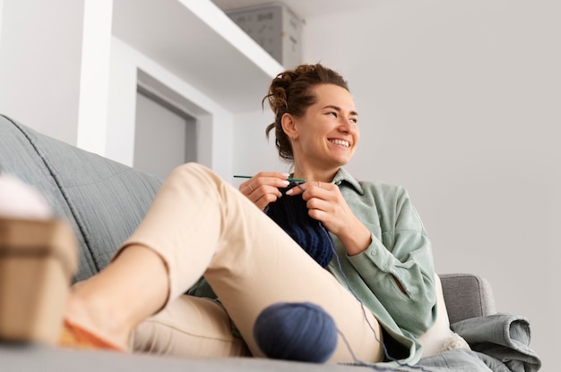 Free photo young adult relaxing while knitting