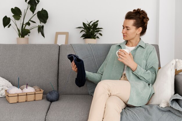 Young adult relaxing while knitting