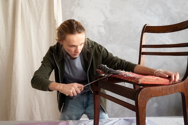 Young adult repairing old chair