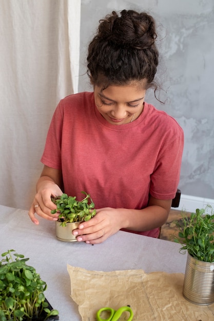 植栽のために缶を再利用する若い大人