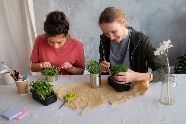 Young adult reusing cans for planting