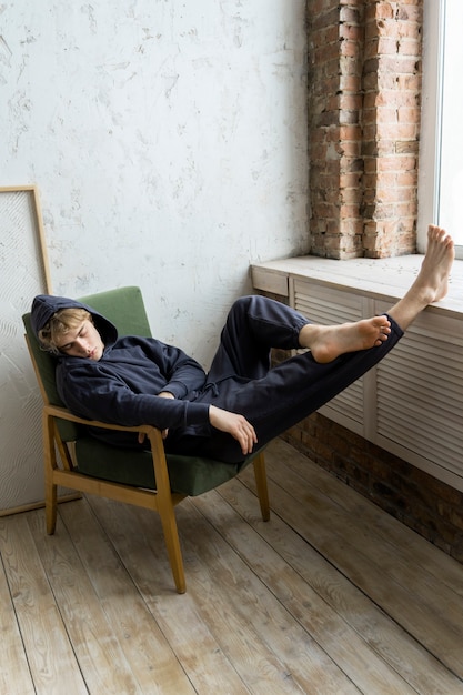 Free photo young adult sleeping on chair