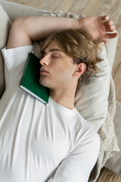 Giovane adulto che dorme durante la lettura
