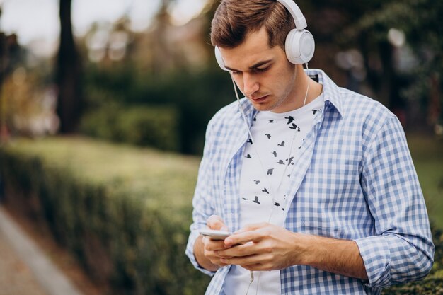 Young adult student walking down the street with headphones