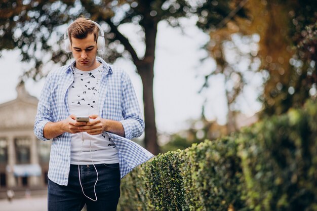 Young adult student walking down the street with headphones