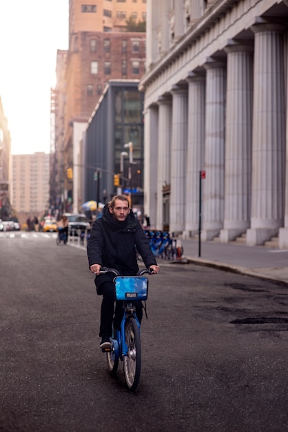 Free photo young adult using bike to travel in the city