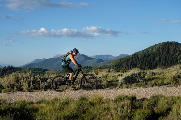 Foto gratuita giovani adulti che utilizzano la bici elettrica in campagna