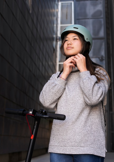 Foto gratuita giovane adulto che utilizza uno scooter elettrico per il trasporto