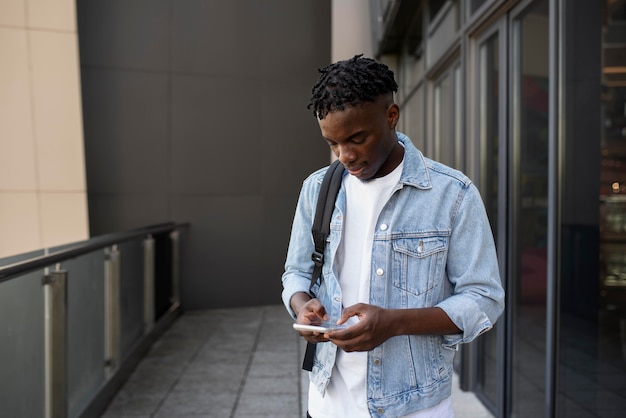 Free photo young adult using his digital device