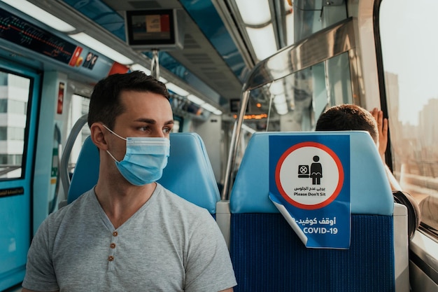 대중 교통에서 얼굴에 천 마스크를 쓰고 호흡기 보호 장치를 사용하는 젊은 성인