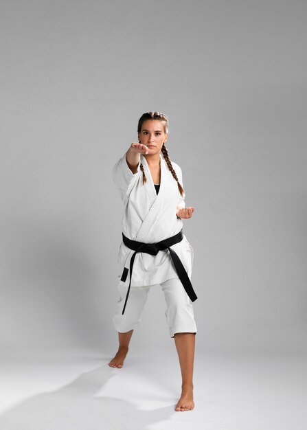 Young adult woman with black belt fighter training karate