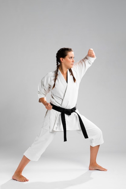 Young adult woman with black belt fighter training karate