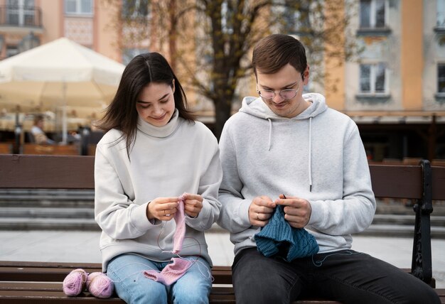 Young adults knitting outside