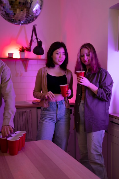 Young adults playing beer pong