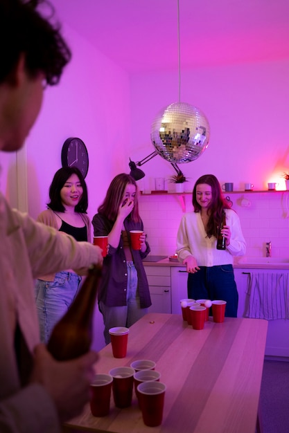 Young adults playing beer pong