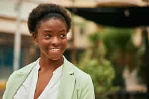 Free photo young african american businesswoman smiling happy standing at the city