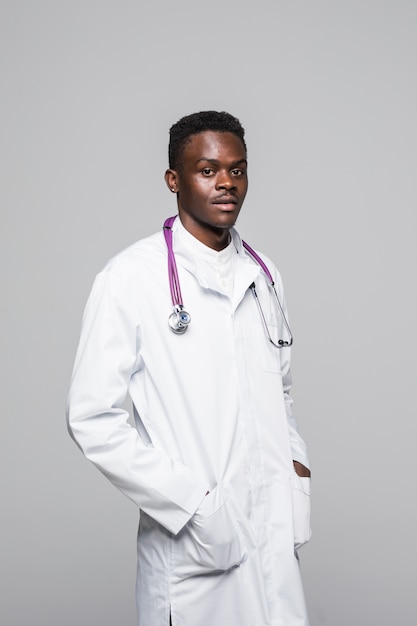 Young African American doctor in white uniform isolated on white background standing with arms in pocked looking professional and highly competent in field of medical specialization