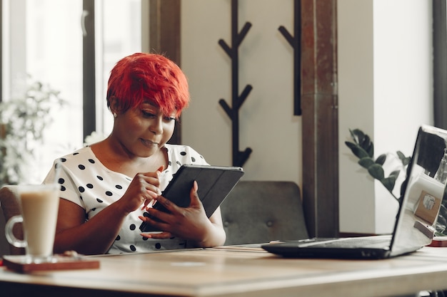 Young African American female working in an office. Lady in a white blouse.