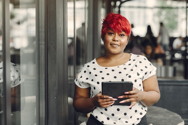 Young African American female working in an office. Lady in a white blouse.