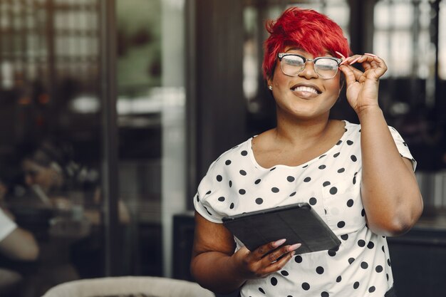 Young African American female working in an office. Lady in a white blouse.