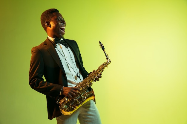 Молодой афро-американский джазовый музыкант играет на саксофоне