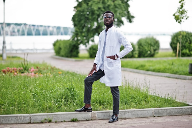 청진 기 흰색 코트에 젊은 아프리카 계 미국인 남성 의사가 야외 포즈