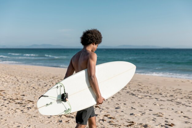 Young African American male going surfing