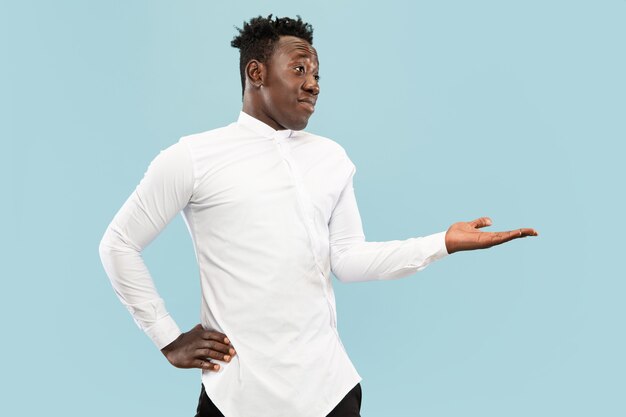 Young african-american man isolated on blue studio background