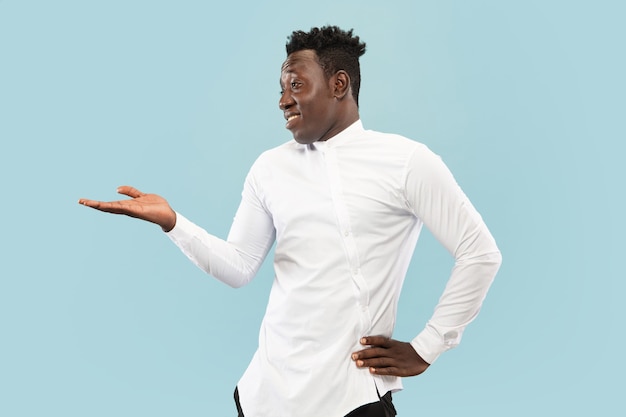 Young african-american man isolated on blue studio background