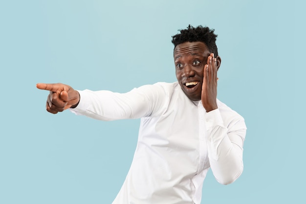 Young african-american man isolated on blue studio background