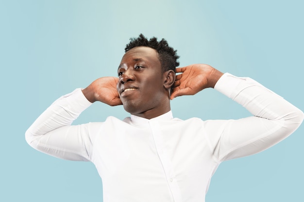 Free photo young african-american man isolated on blue studio background