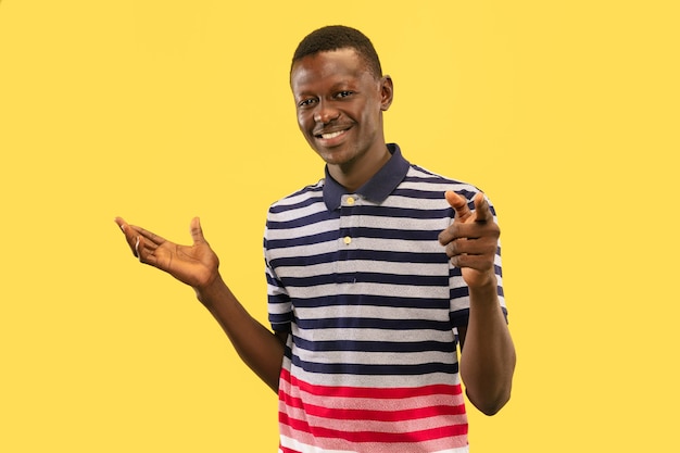 Young african-american man isolated on yellow studio background, human emotions concept.