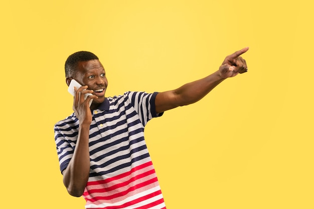 Young african-american man isolated on yellow studio background, human emotions concept.