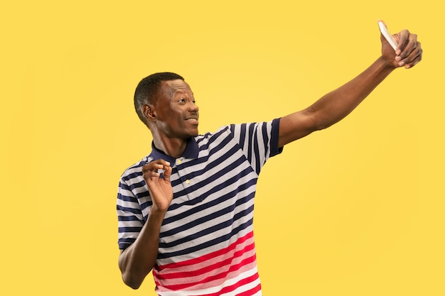 Young african-american man isolated on yellow studio, human emotions concept.