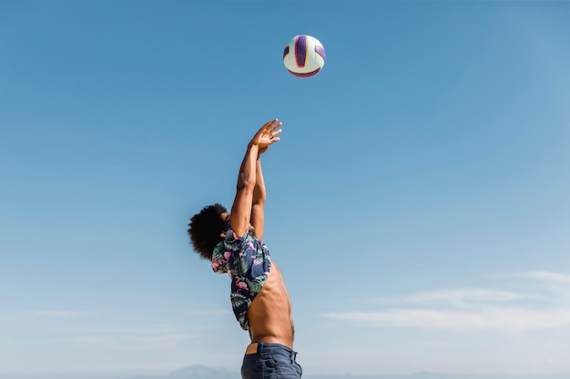 Молодой афроамериканец человек прыгает и бросает мяч