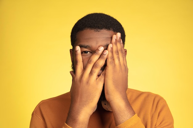 Портрет молодого афро-американского человека, изолированные на желтом, выражение лица. Premium Фотографии