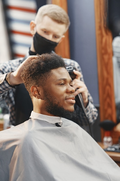 Free photo young african-american man visiting barbershop