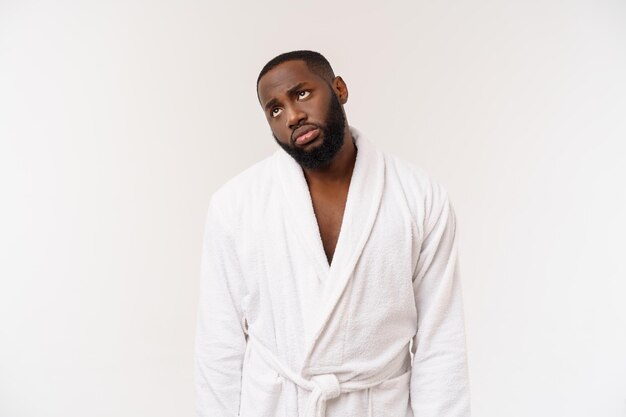 Young african american man wearing bathrobe over isolated white background thinking looking tired and bored with depression problems