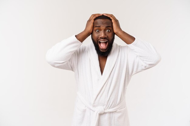 Молодой африканский американец в халате на изолированном белом фоне думает, что выглядит уставшим и скучающим по проблемам депрессии