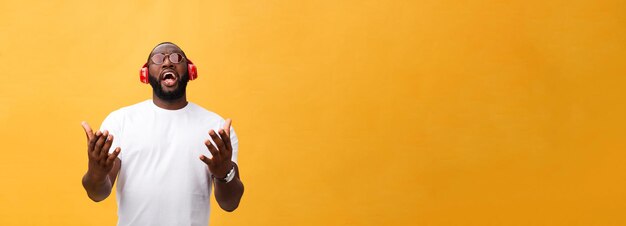 Молодой афроамериканец человек носить наушники и наслаждаться музыкой на фоне желтого золота