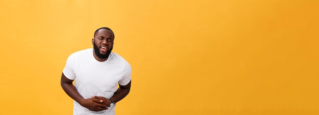 Young african american man wearing white tshirt with hand on stomach because nausea painful disease