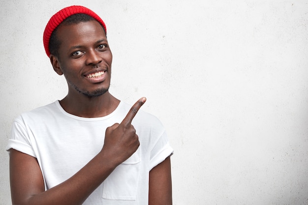 Giovane uomo afro-americano in maglietta bianca e cappello rosso