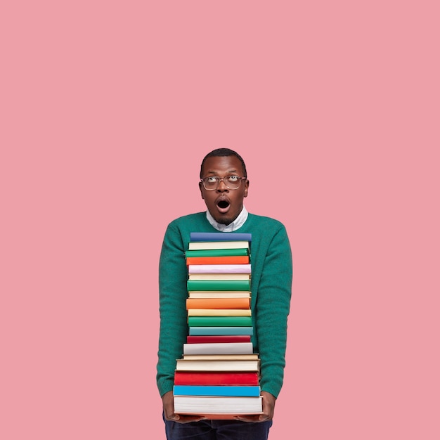 Free photo young african american student holding pile of books