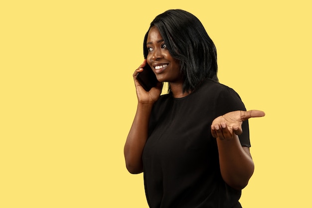 Молодая афро-американская женщина, изолированная на желтом, выражение лица