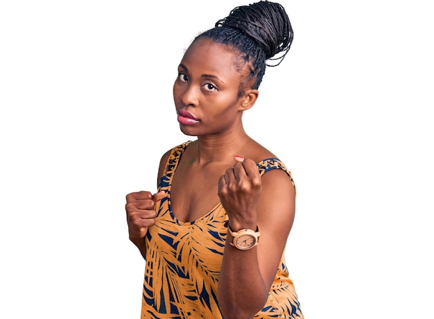 Free photo young african american woman wearing casual clothes ready to fight with fist defense gesture, angry and upset face, afraid of problem