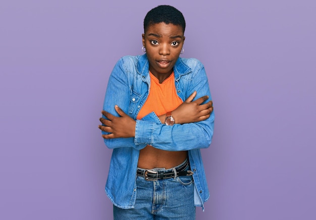 Free photo young african american woman wearing casual clothes shaking and freezing for winter cold with sad and shock expression on face