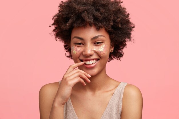 Young African-American woman with glitter on face