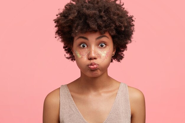 Молодая афро-американская женщина с блеском на лице